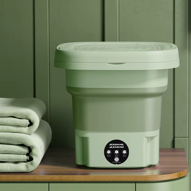 Green collapsible laundry basket on a wooden surface with green cabinets in the background Secondary image